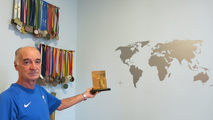 Antônio Borges no quarto de Hugo, com mais de 300 medalhas e troféus (Foto: Carol Fontes)