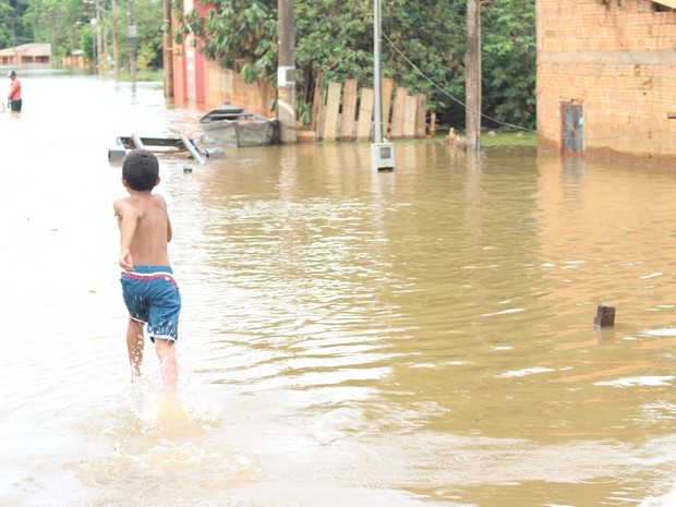 Criança brinca em água contaminada no Bairro do Belmont (Foto: Suzi Rocha/G1)