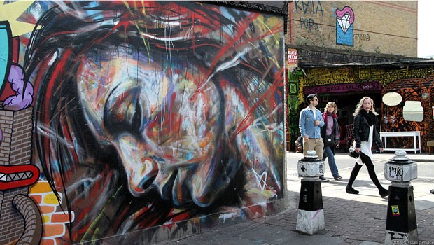 Quando parlamentares britânicos aprovaram uma lei em 2003 para tornar ilegal o grafite em cidades inglesas, eles não esperavam que Londres se tornaria uma das capitais mundiais desse tipo de arte, com artistas locais ganhando fama internacional. David Walker, que pintou o mural "Noivas em chamas" perto da conhecida rua Brick Lane, no leste de Londres, ganhou fama por suas apresentações de grafitagem "ao vivo". Hoje ele vende em sua própria loja, versões impressas de seus trabalhos.  (Foto: David Walker/BBC)