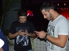 Henri Castelli e Daniel Rocha interagem com celular em show