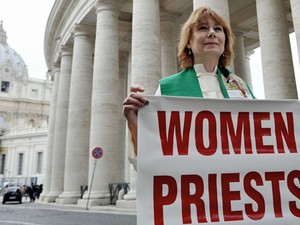 Janice Sevre-Duszynska com a placa 'Mulheres sacerdotes estão aqui!', no Vaticano, nesta quinta-feira (7) (Foto: Tiziana fabi/AFP)