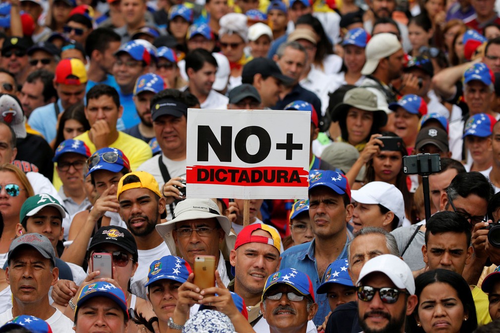 Manifestantes seguram placa de 'não à ditadura' eem protesto contra o presidente da Venezuela, Nicolas Maduro, organizado em Caracas no Dia do Trabalhador, nesta segunda-feira, dia 1º de maio de 2017 (Foto: Carlos Garcia Rawlins/Reuters)