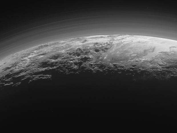 Quinze minutos depois de atingir o ponto mais próximo com Plutão, a sonda New Horizons fez essa imagem do planeta-anão em que aparecem as montanhas e planícies de gelo (Foto: NASA/JHUAPL/SwRI)