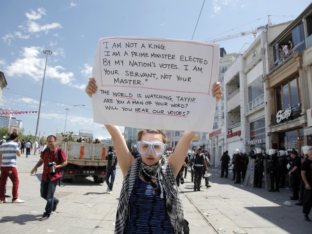 Manifestante empunha cartaz com frases contra o primeiro-ministro turco: 'Eu não sou um rei, eu sou um primeiro-ministro eleito pelo povo. Sou seu servo, não seu mestre.' (Foto: Gurcan Ozturk/AFP)