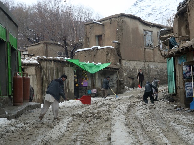 Homens retiram neve e terra das ruas da província de Panjshir, no Afeganistão, na quarta-feira (25) (Foto: AP Photo/Massoud Hossaini)