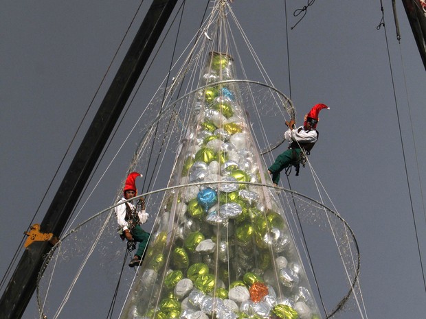 Pessoas vestidas de elfos se preparam para soltar balões de uma árvore de Natal como parte das comemorações à frente do Dia de Reis, no bairro Iztapalapa da Cidade do México. É costume no México celebrar o Dia de Reis neste 6 de janeiro em vez de dar pres (Foto: AP Photo/Marco Ugarte)
