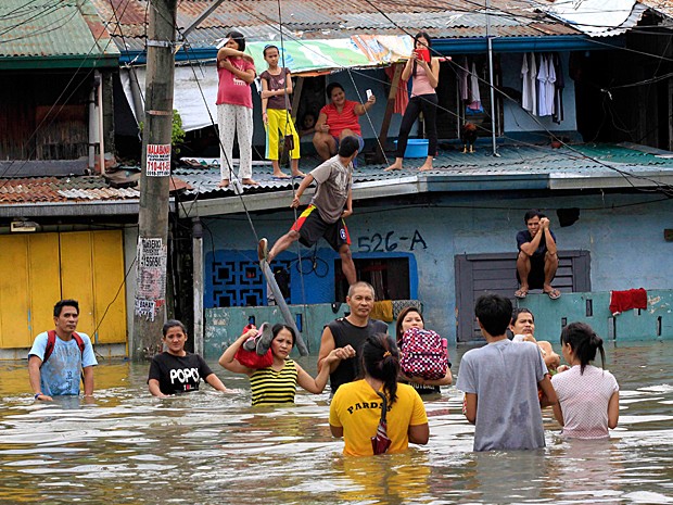 Moradores de Cainta, na província de Rizal, a leste de Manila, passam por enchente durante a tempestade tropical  (Foto: Romeo Ranoco/Reuters)