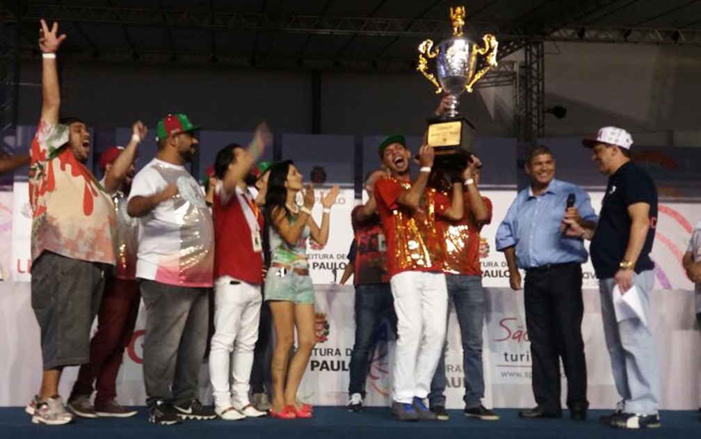 Integrantes da X-9 Paulistana levantam a taça de campeã do Grupo de Acesso (Foto: Carolina Dantas/G1)