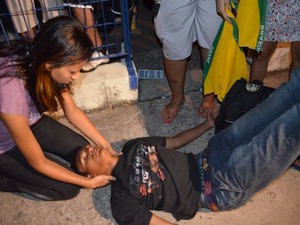 Manifestante que permaneceu sentado em frente à polícia passou mal e desmaiou após inalar fumaça de bombas de efeito moral (Foto: Flávio Antunes/G1)