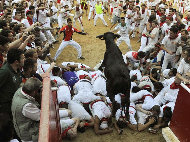 Touros são soltos de currais e correm em meio às pessoas; corrida desta manhã durou dois minutos e vinte e cinco segundos (Foto: Eloy Alonso/Reuters)