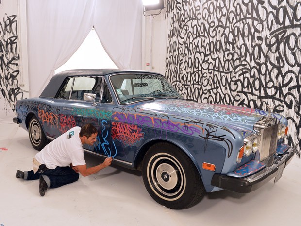 O grafiteiro norte-americano Jonone usou como parede o Rolls Royce do ex-jogador de futebol francês Eric Cantona. A arte foi feita durante o programa de TV "Le grand journal", do Canal + TV como parte do lançamento de uma campanha de caridade de inverno n (Foto: MIGUEL MEDINA/AFP)