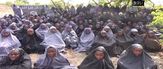 Imagem de vídeo divulgado pelo Boko Haram mostra meninas com vestes islâmicas rezando ao ar livre. Jovens seriam as sequestradas em abril na Nigéria (Foto: Boko Haram/AFP)