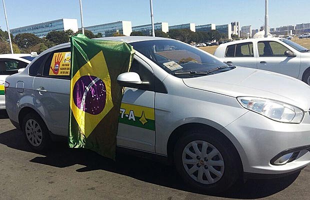 Taxistas trafega com bandeira do Brasil na janela durante carreata na Esplanada dos Ministérios (Foto: Isabella Calzolari/G1)
