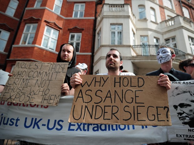 Manifestantes pró-Assange demonstram seu apoio em frente ao prédio da embaixada equatoriana, em Londres, neste domingo (19) (Foto: Carl Court/AFP)