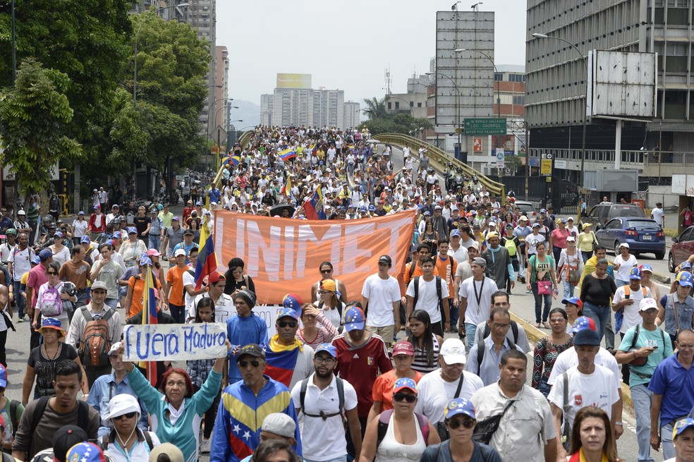 Manifestantes protestam contra o governo de Nicolás Maduro em uma avenida de Caracas (Foto: FEDERICO PARRA / AFP)