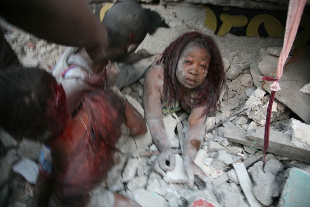 Pessoas são retiradas de sob escombros em foto feita por Daniel Morel após o terremoto que atingiu o Haiti em janeiro de 2010 (Foto: Daniel Morel/photomorel.com)
