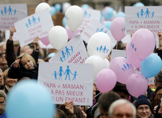 Manifestantes seguram cartazes e balões durante manifestação em Paris. A lei garante aos casais gays o direito de adotar crianças, mas não permite a utilização de métodos de reprodução assistida, como a inseminação artificial. Parlamento deve votá-lo até meados de 2013. Líderes religiosos e políticos conservadores são contra. (Foto: Christian Hartmann/Reuters)