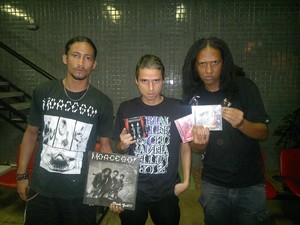 Integrantes da banda exibem alguns dos álbuns lançados na carreira (Foto: Derek Gustavo/G1)