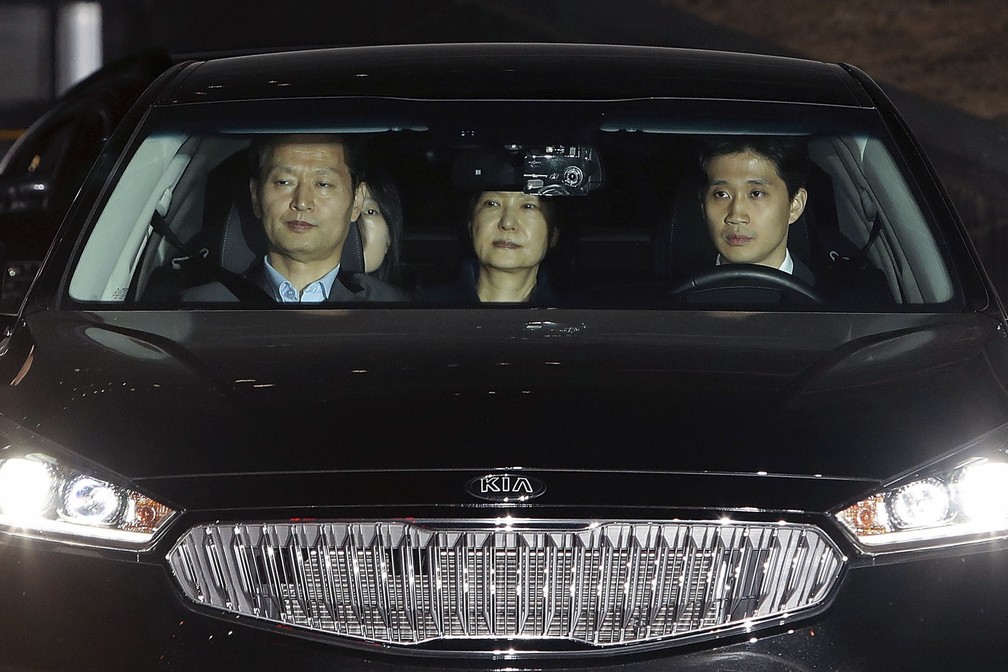 Park, ao centro, a bordo do carro em que foi levada para o centro de detenção (Foto: Chung Sung-Jun/Pool photo via AP)