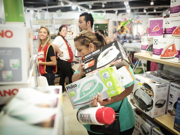 Consumidora mal consegue segurar suas compras (Foto: Caio Kenji/G1)