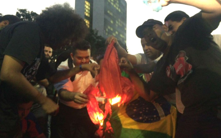 Manifestantes queimam bandeira do PT em ato contra o governo Dilma atrás do Congresso Nacional