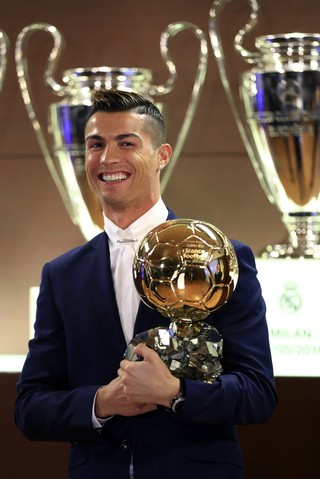 Cristiano Ronaldo com a Bola de Ouro da France Football em frente a algumas taças da Liga dos Campeões do Real Madrid (Foto: EFE/Franck Seguin )