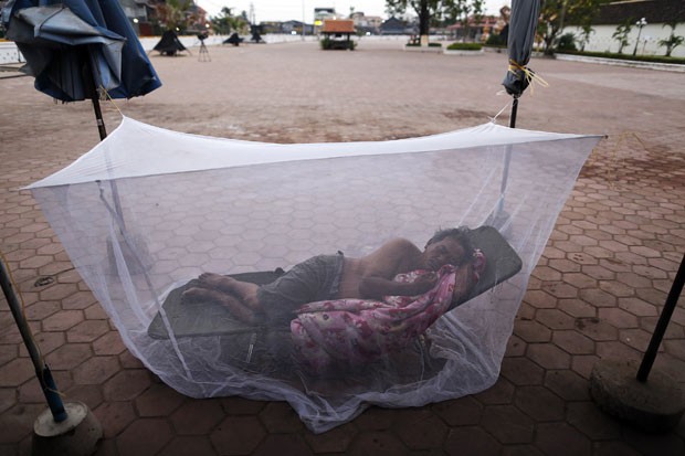 Um homem colocou uma tela de proteção contra mosquistos enquanto dormia neste domingo (4) na região central de Vientiane, capital e maior cidade de Laos. (Foto: Damir Sagolj/Reuters)