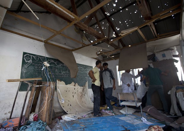 Palestinos inspecionam estragos causados por ataque contra escola da ONU em Gaza; 20 pessoas morreram (Foto: Mahmud Hams/AFP)