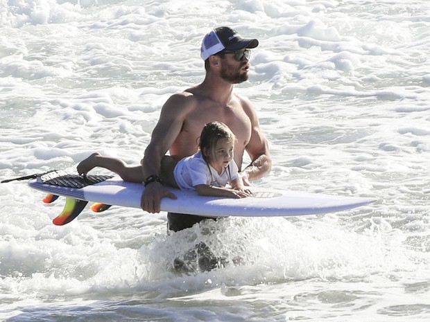 Chris Hemsworth com um dos filhos em praia em Byron Bay, na Austrália (Foto: Grosby Group/ Agência)
