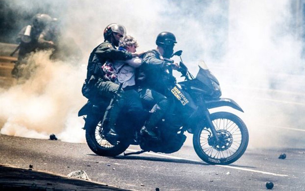 Manifestante desconhecida é levada por policiais da guarda nacional (Foto: Leo Álvarez)