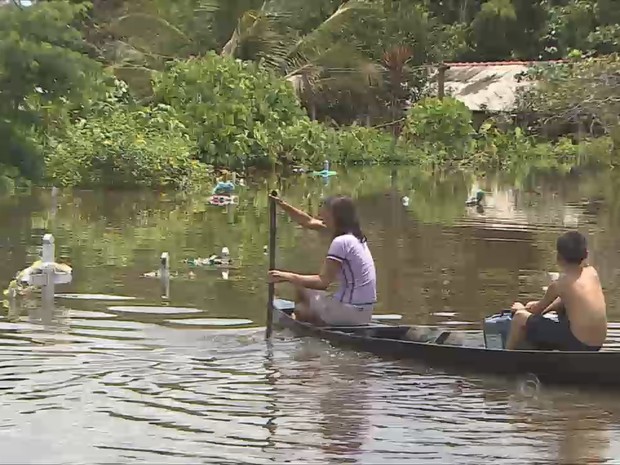 Crianças passeiam de barco sobre as sepulturas no cemitério de Calama (Foto: TV Rondônia/Reprodução)