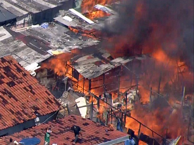 Moradores tentam apagar as chamas com água de caixa d'água (Foto: Reprodução / TV Globo)
