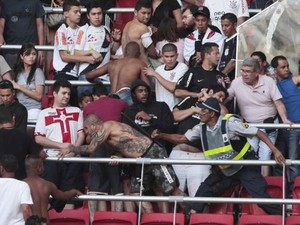 Raimundo Faustino, o Capá (sem camisa), leva cacetada de policial durante confusão no jogo Corinthians e Vasco, em Brasília (Foto: Jorge William / O Globo)