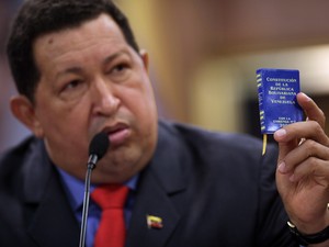 Em foto de 9 de outubro de 2012, o presidente da Venezuela, Hugo Chávez, fala em uma conferência segurando a ministura da constituição do país. (Foto: AP/ ASSOCIATED PRESS)