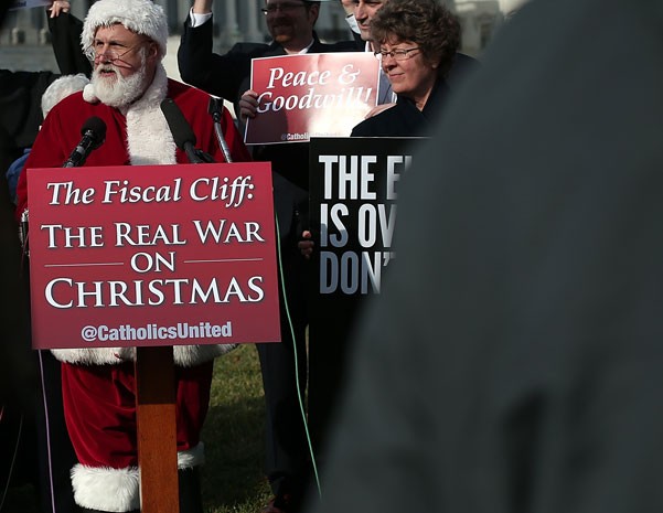 Homem vestido de Papai Noel faz discurso antes de entrar no Congresso os EUA para pedir acordo sobre o abismo fiscal antes do Natal. (Foto: Win McNamee/Getty Images/AFP)