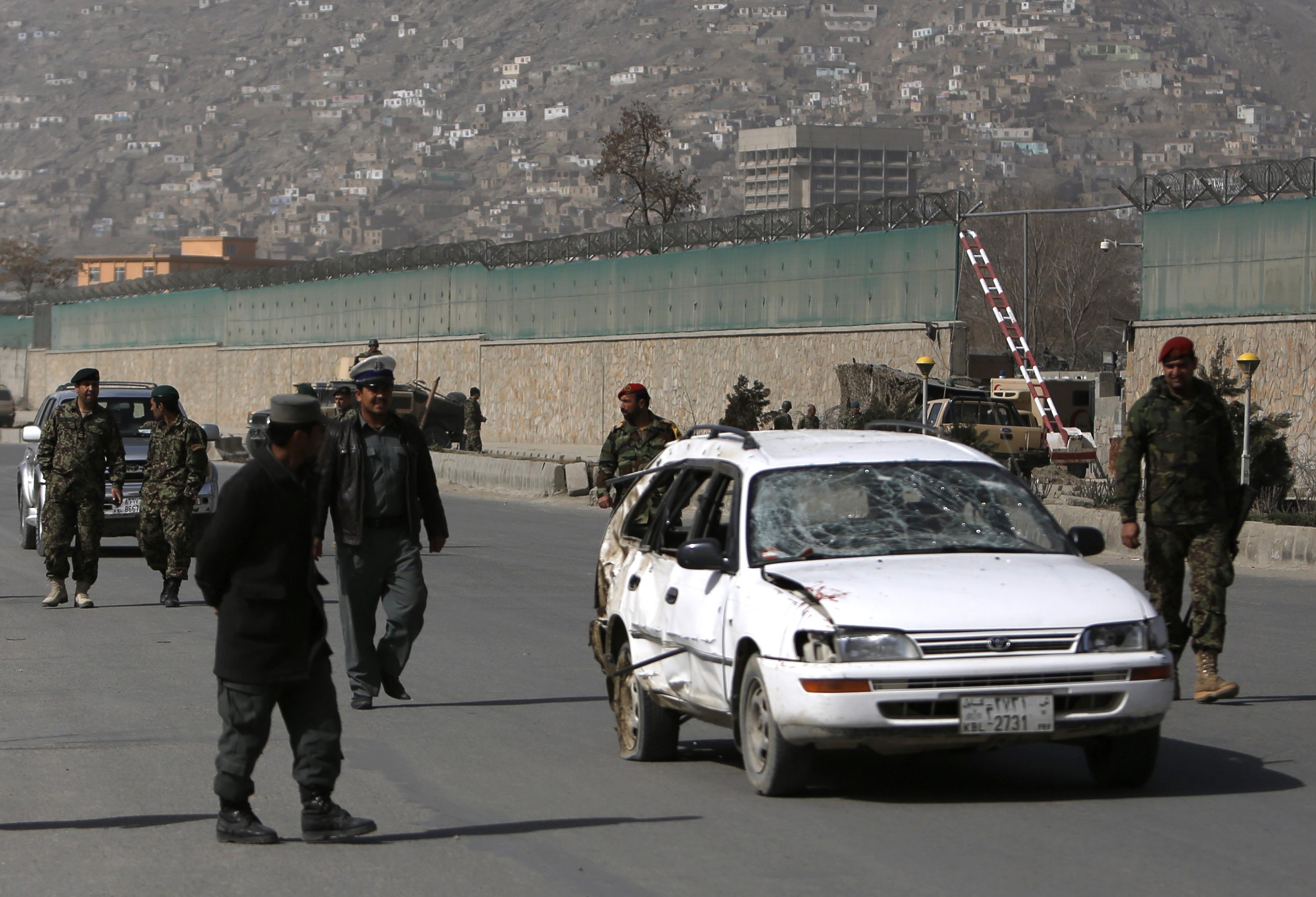 Soldados afegãoes retiram carro de área onde houve atentado com homem-bomba (Foto: Mohammad Ismail/Reuters)
