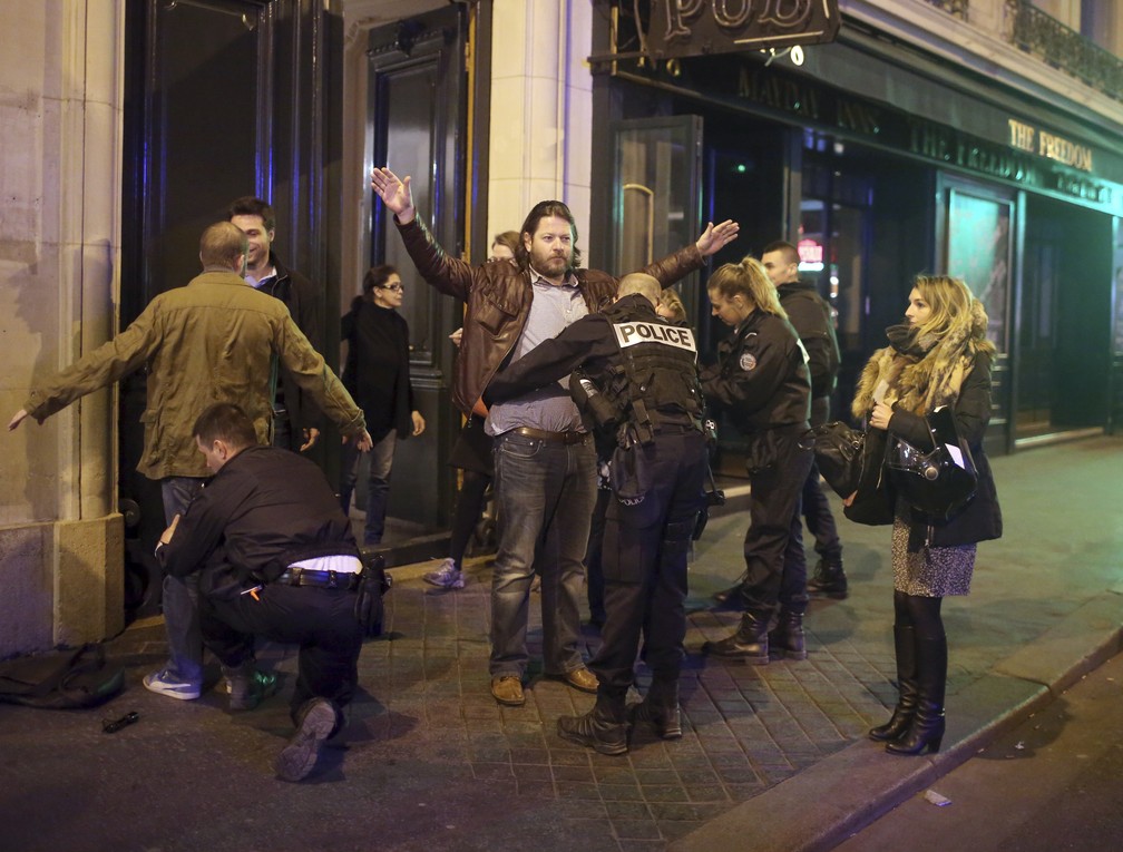 Policiais revistam pessoas após tiroteio na avenida Champs-Élysées, em Paris (Foto: AP Photo/Thibault Camus) Policiais revistam pessoas após tiroteio na avenida Champs-Élysées, em Paris (Foto: AP Photo/Thibault Camus)