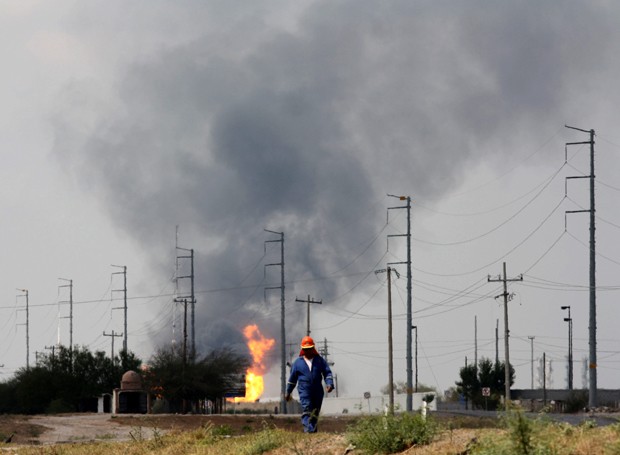 Funcionário caminha próximo a refinaria em Reynosa logo após acidente (Foto: AP Photo/El Manana de Reynosa)
