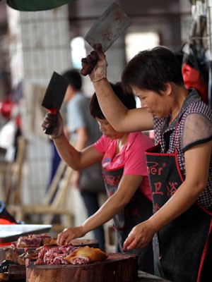 Fornecedores cortam a carne em um mercado em Yulin (Foto: Humane Society International/ AP)