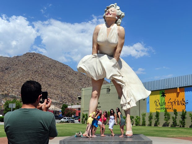Fãs de Marilyn Monroe visitam estátua em homenagem à atriz em Palm Springs, na Califórnia, na véspera do dia em que se completam 50 anos da morte da estrela (Foto: Frederic J. Brown/AFP)