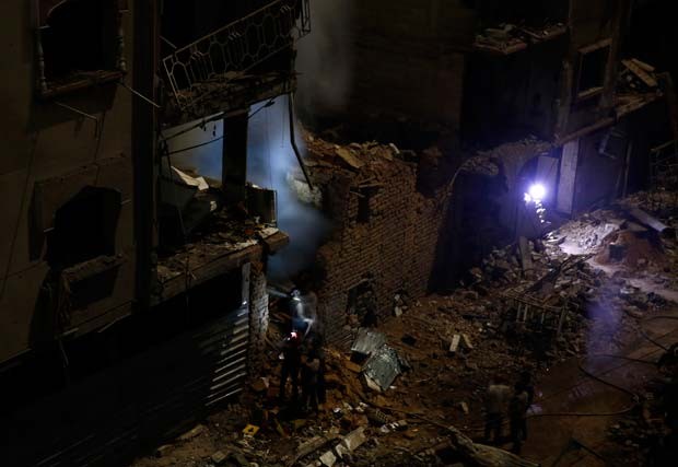 Equipe de emergência chega a prédio destruído nesta sexta-feira (30) depois de bombardeio pelo regime sírio (Foto: FP PHOTO / SAMEER AL-DOUMY)