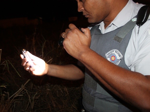 Policial mostra o celular do assaltante encontrado no veículo (Foto: Votunews)
