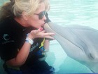 Adriane Galisteu beija golfinho em parque aquático
