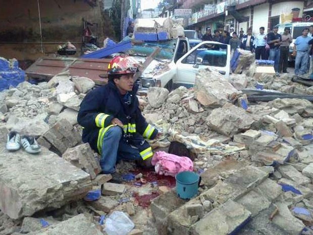 Bombeiro em meio a desabamento provocado pelo terremoto desta quarta-feira (7) em San Marcos, na Guatemala (Foto: AFP)
