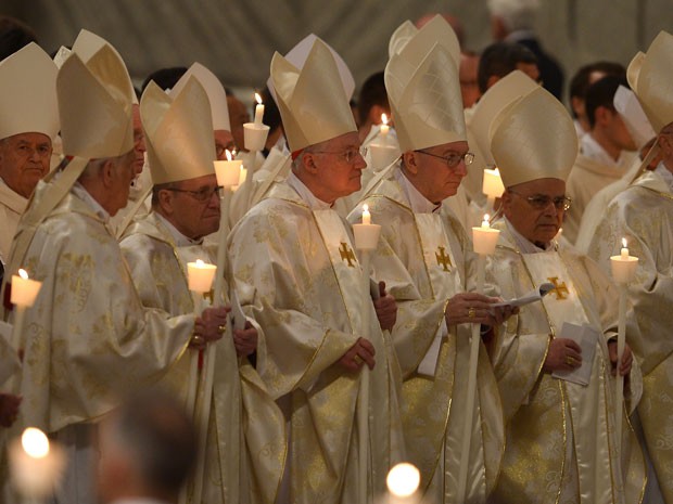 Na Basílica de São Pedro, religiosos seguram velas durante a Vigília Pascal (Foto: Filippo Monteforte/AFP)