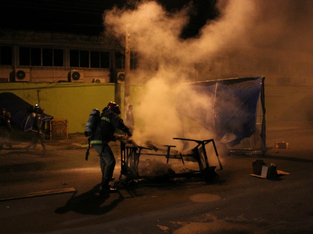 Bombeiro retira resto de entulho usado em fogueira (Foto: Romulo de Sousa/G1 AM)