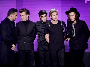 Os integrantes do One Direction (a partir da esq.), Liam Payne, Louis Tomlinson, Zayn Malik, Niall Horan e Harry Styles, recebem o prêmio de melhor álbum de pop/rock no American Music Awards pelo disco 'Midnight mmories' (Foto: Kevin Winter/Getty Images/AFP)