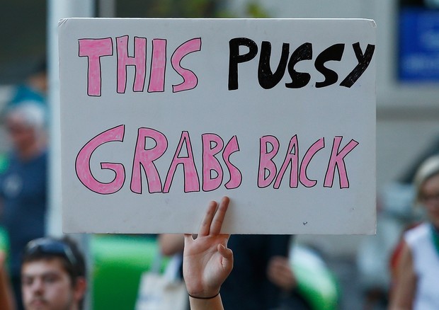 "Esta b* revida", diz o cartaz de manifestante em Melbourne, fazendo alusão ao terrível episódio de assédio de Trump (Foto: Getty Images)