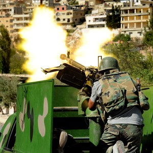  Soldado militar sírio dispara metralhadora durante confrontos com rebeldes na aldeia Maaloula, a nordeste da capital Damasco  (Foto: AP Photo/SANA)