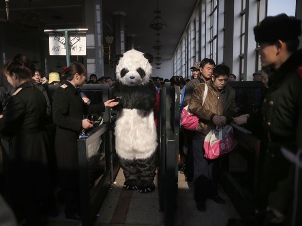 Passageira aparece vestida de panda para viajar na Estação de Trem de Pequim, na China, durante o Ano Novo Chinês (Foto: Kevin Zhao/Reuters)